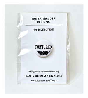 Tortured, 1" Pin back button, in honor of Taylor Swift's album, The Tortured Poets Department, black lettering and feather drawing on white background, packaged on recycled paper, in 100% compostable clear glassine bag